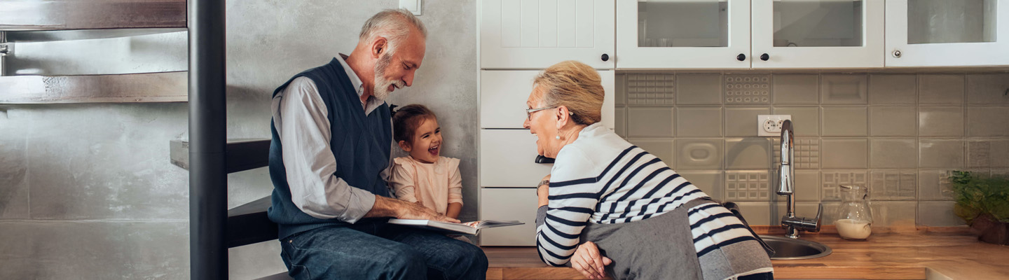 grandparents reading book with granddaughter