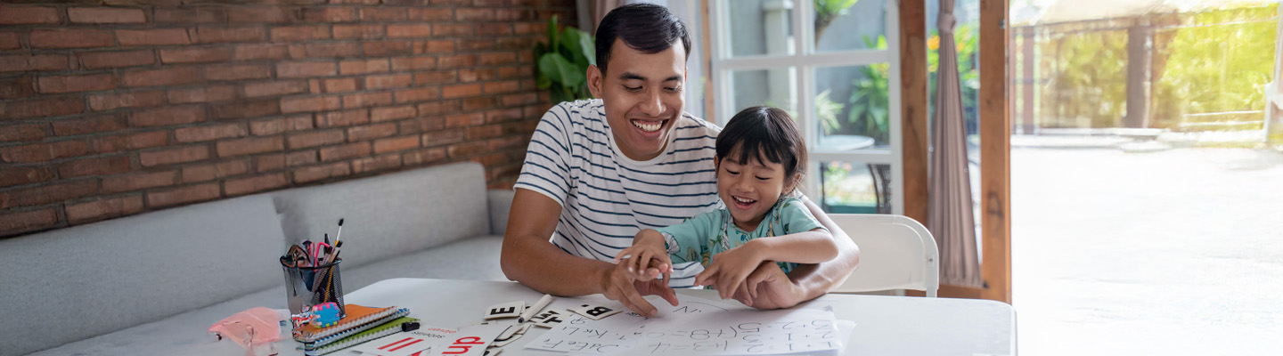 portrait of asian toddler studying with her father at home