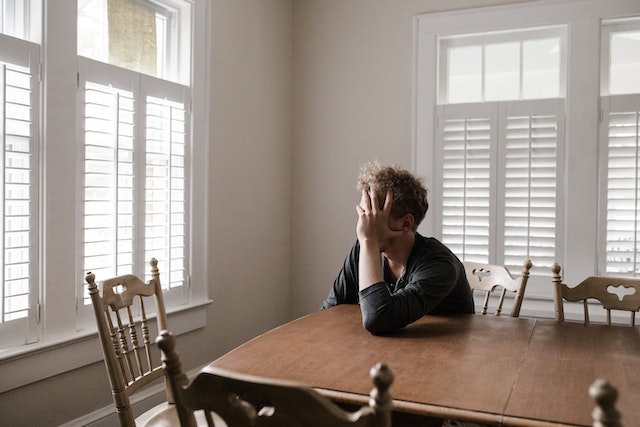 stressed man sitting alone at table