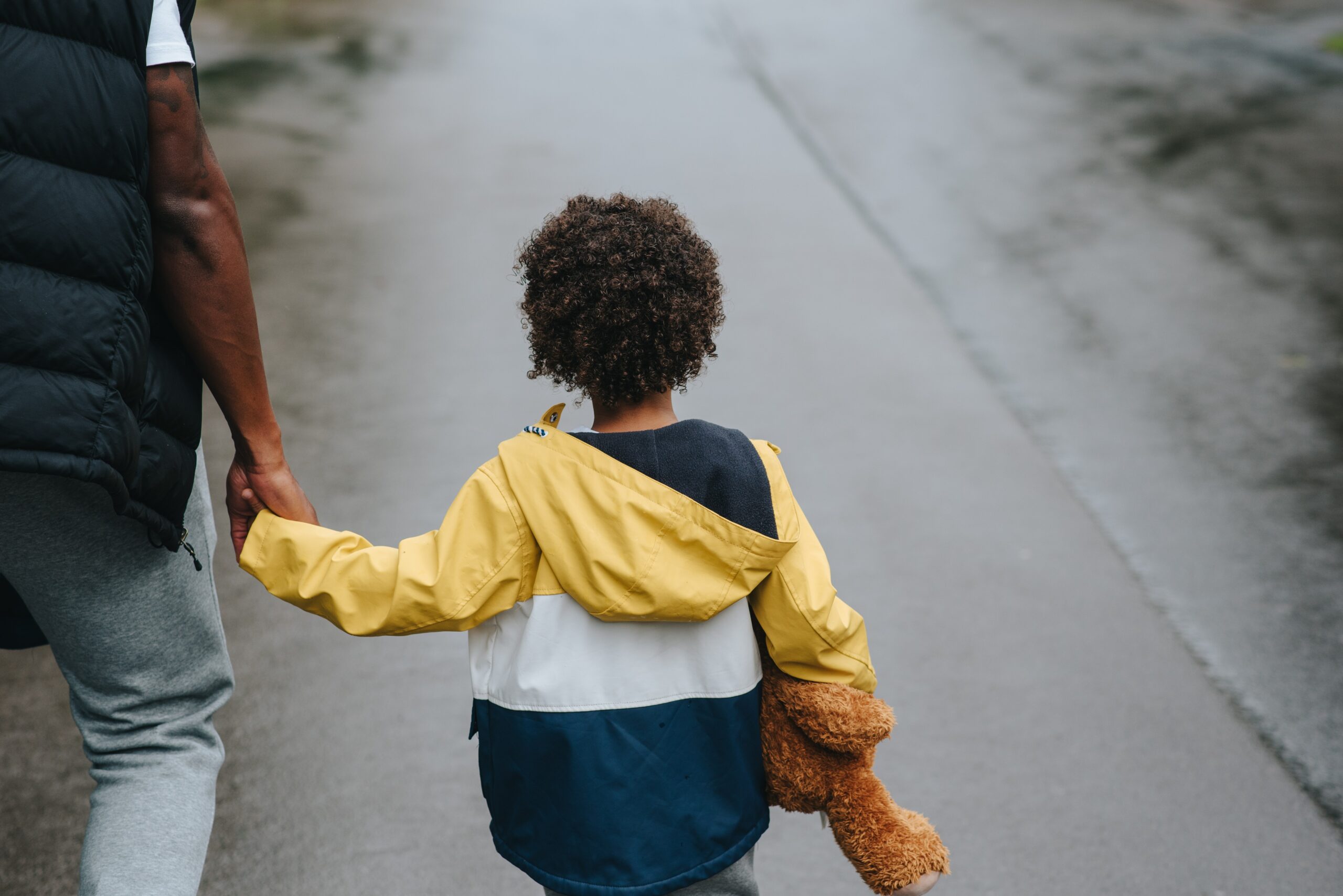 man holding hand with child walking
