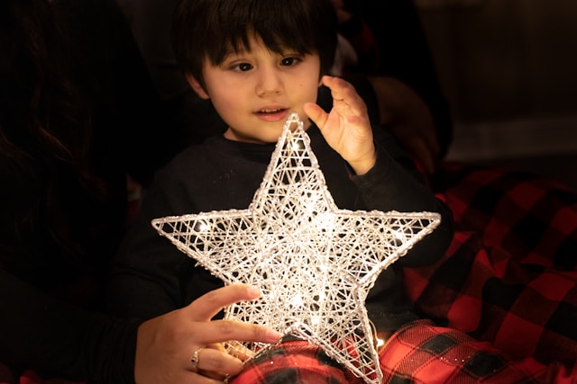 child holding a lit wire star