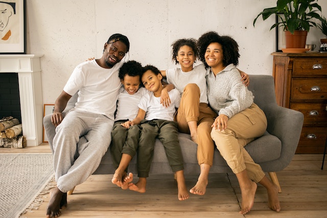 family sitting and smiling on couch
