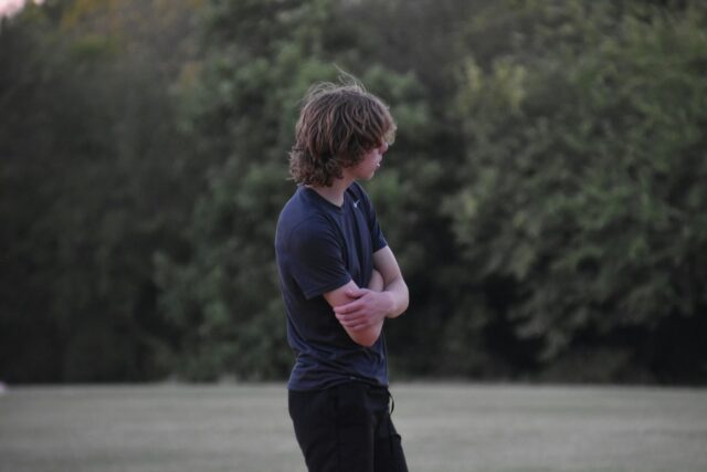 teenager standing with arms crossed